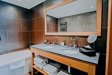 A bathroom with two sinks and a large mirror