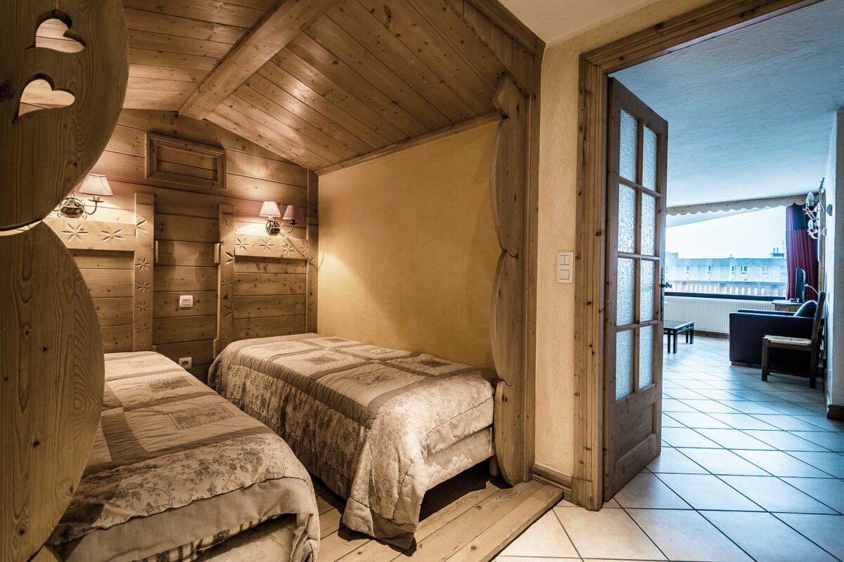 A bedroom with two beds and a sliding glass door