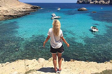 a woman looking at the sea in a small bay in mallorca