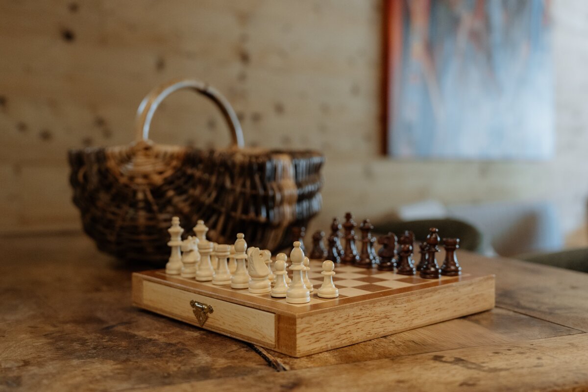 A wooden chess board with a basket in the background