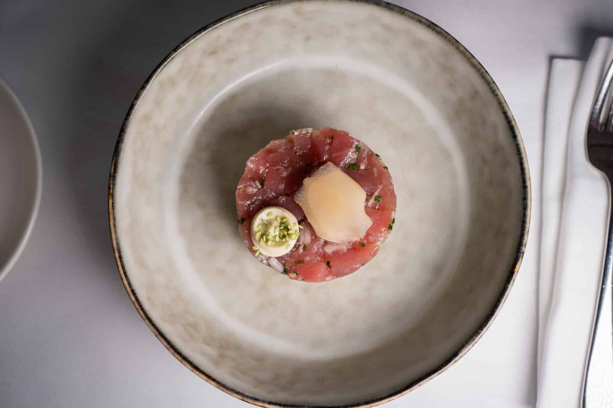 A white plate with a small piece of meat on it