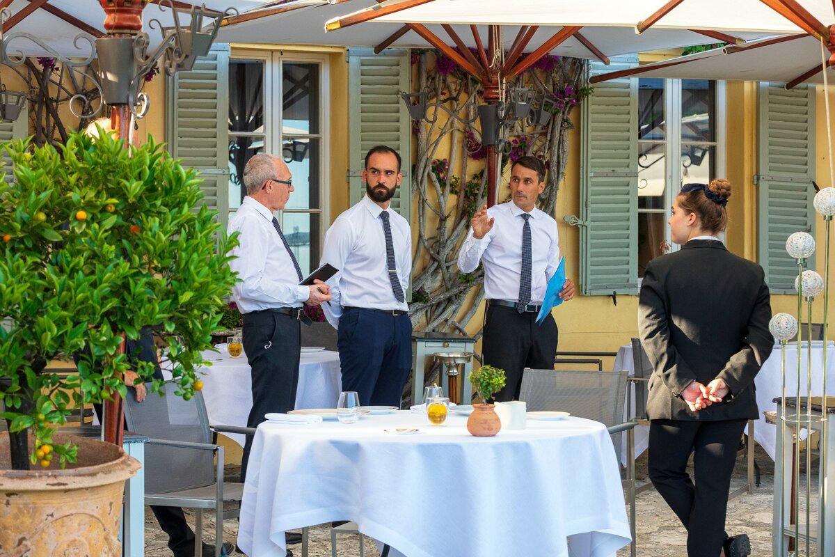 A group of people standing around a table in a restaurant