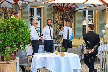 A group of people standing around a table in a restaurant