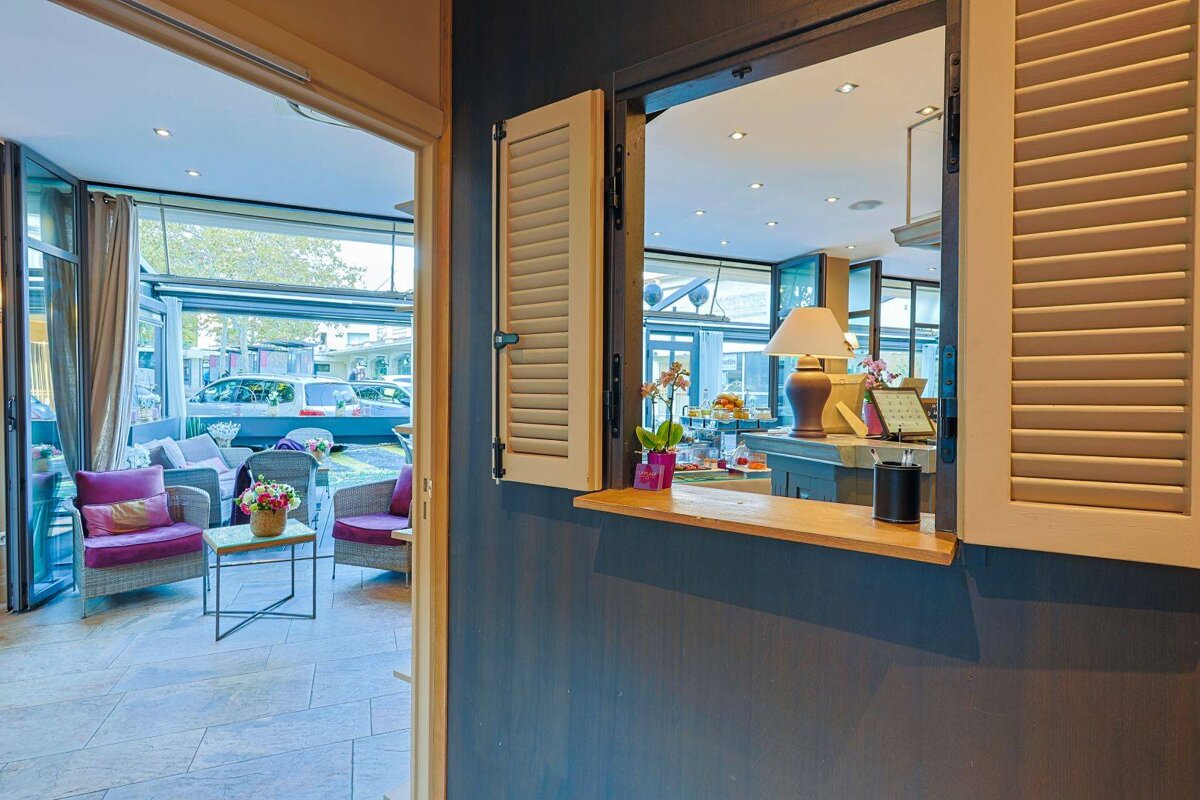 A window with shutters on it is open to a restaurant