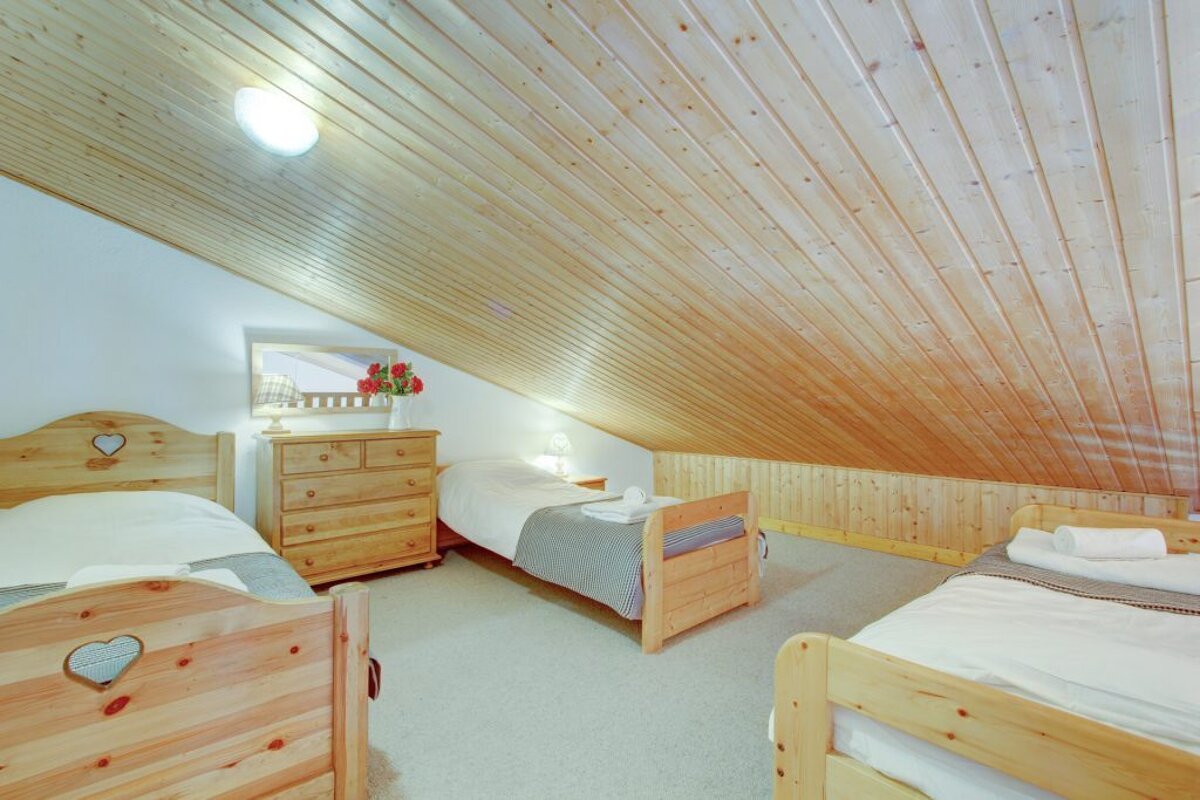 A bedroom with two beds and a dresser