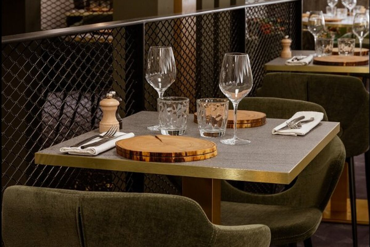 A restaurant with a table set with glasses and utensils