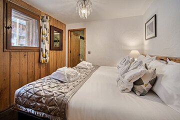 A bedroom with a large bed and a mirror