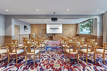 A room with a projector screen that says annapurna on it