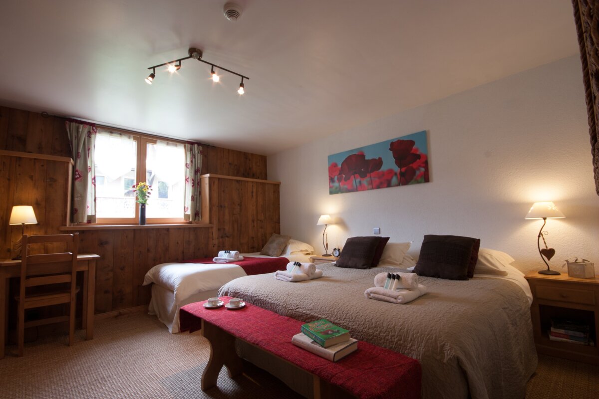 A bedroom with two beds and a painting on the wall