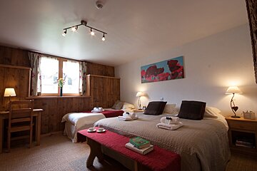 A bedroom with two beds and a painting on the wall