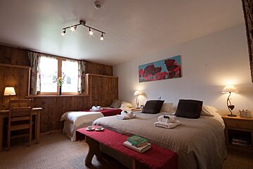 A bedroom with two beds and a painting on the wall