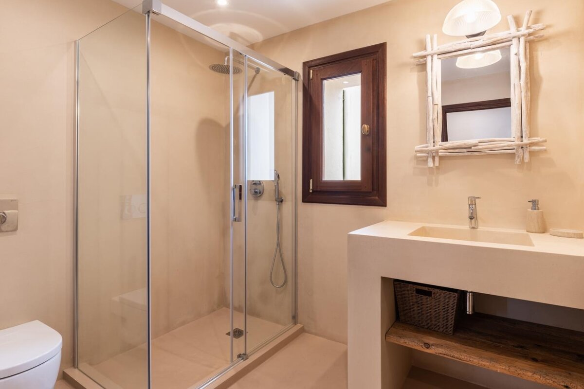 A bathroom with a walk in shower and a sink