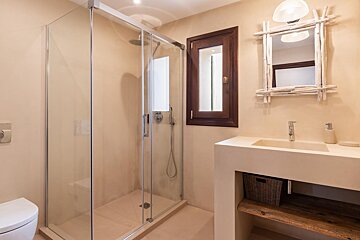 A bathroom with a walk in shower and a sink