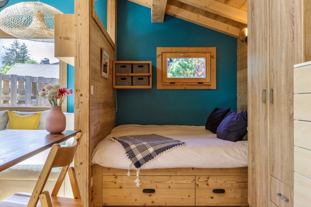 A bed in a small room with blue walls