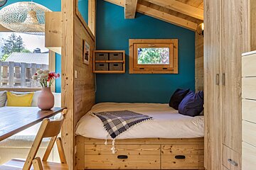 A bed in a small room with blue walls