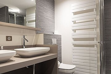 A bathroom with two sinks and a toilet