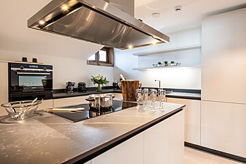 A kitchen with a stainless steel hood and a siemens oven