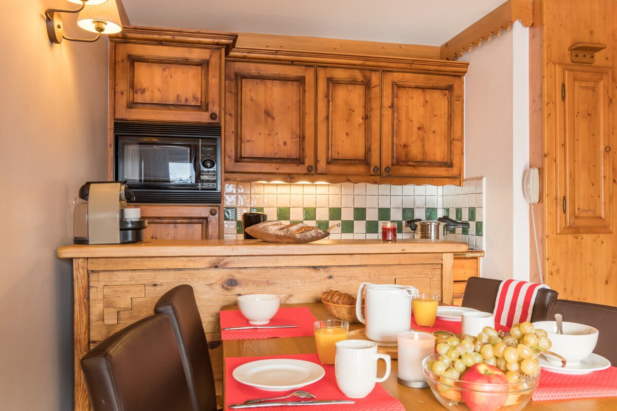 A kitchen with wooden cabinets and a microwave
