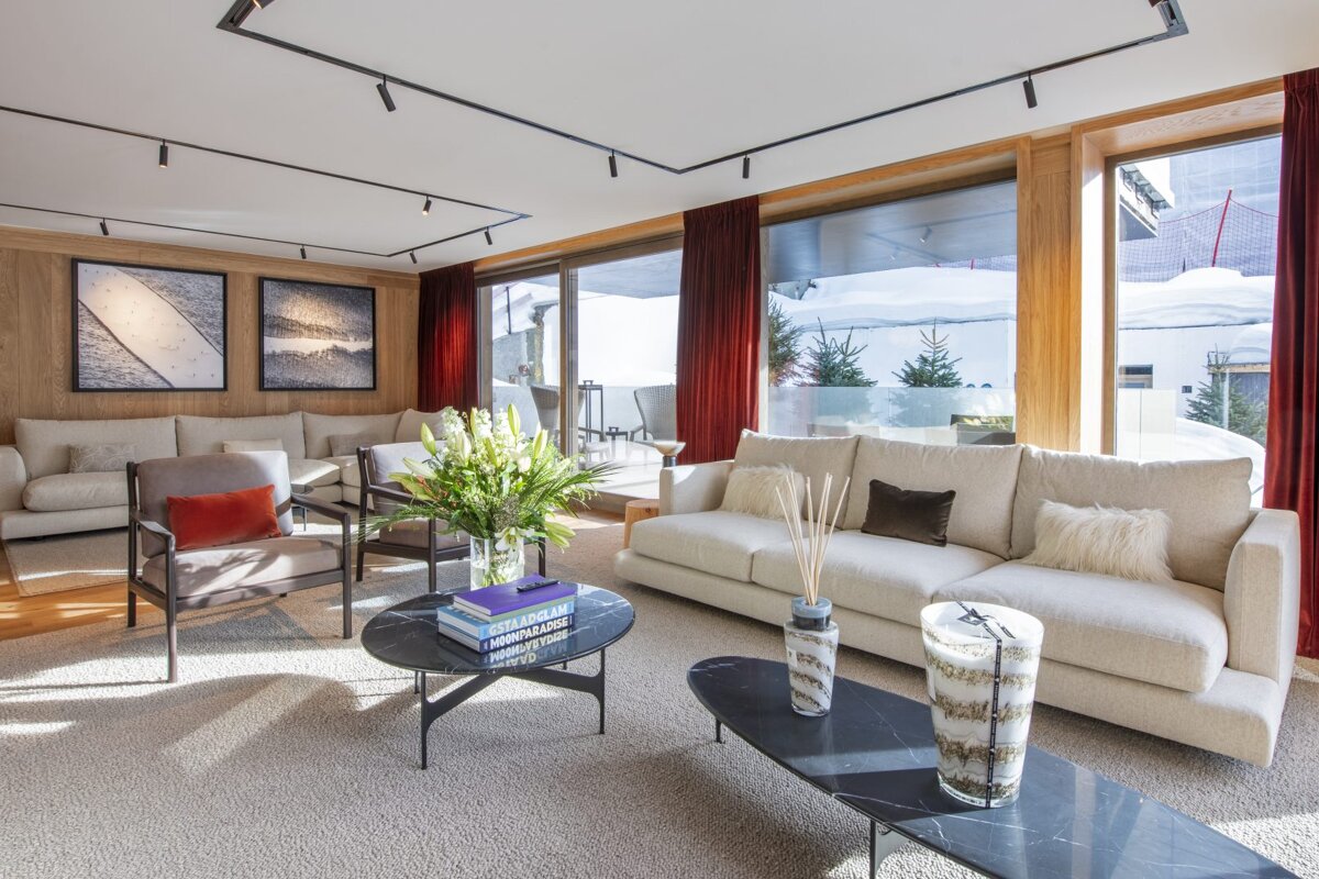 A living room with a couch a table and a vase of flowers