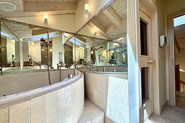 A bathroom with a bathtub and a large mirror