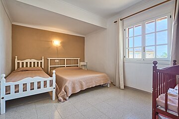 A bedroom with two beds and a crib