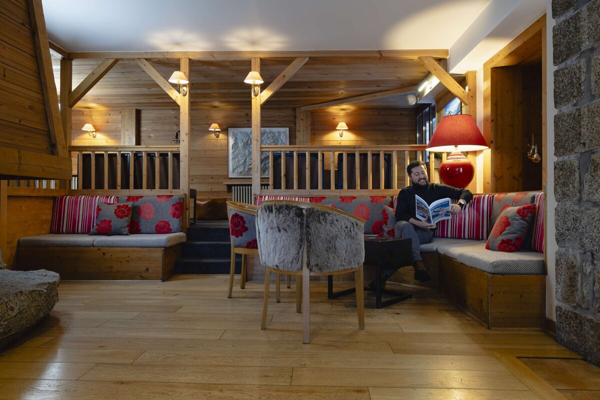 A man sits in a chair reading a magazine