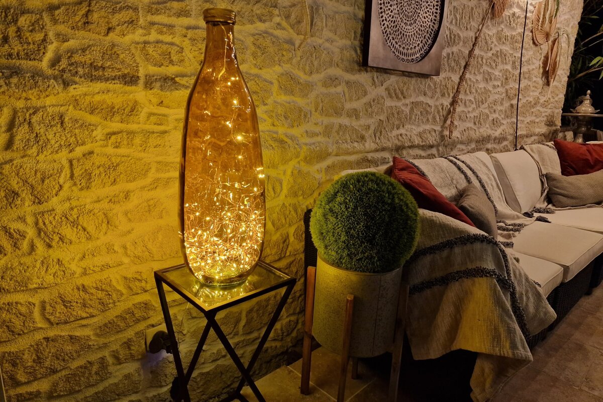 A living room with a couch and a vase with lights inside