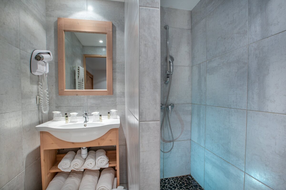 A bathroom with a sink a mirror and a hair dryer