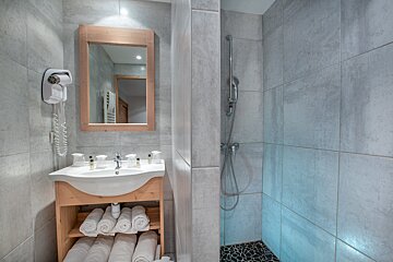 A bathroom with a sink a mirror and a hair dryer