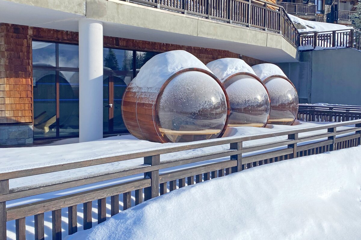 A row of wooden eggs are covered in snow