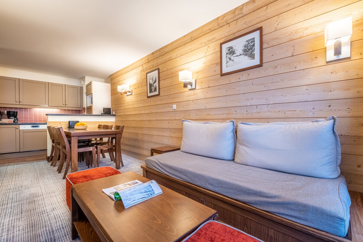 A living room with a couch and a table with a newspaper on it