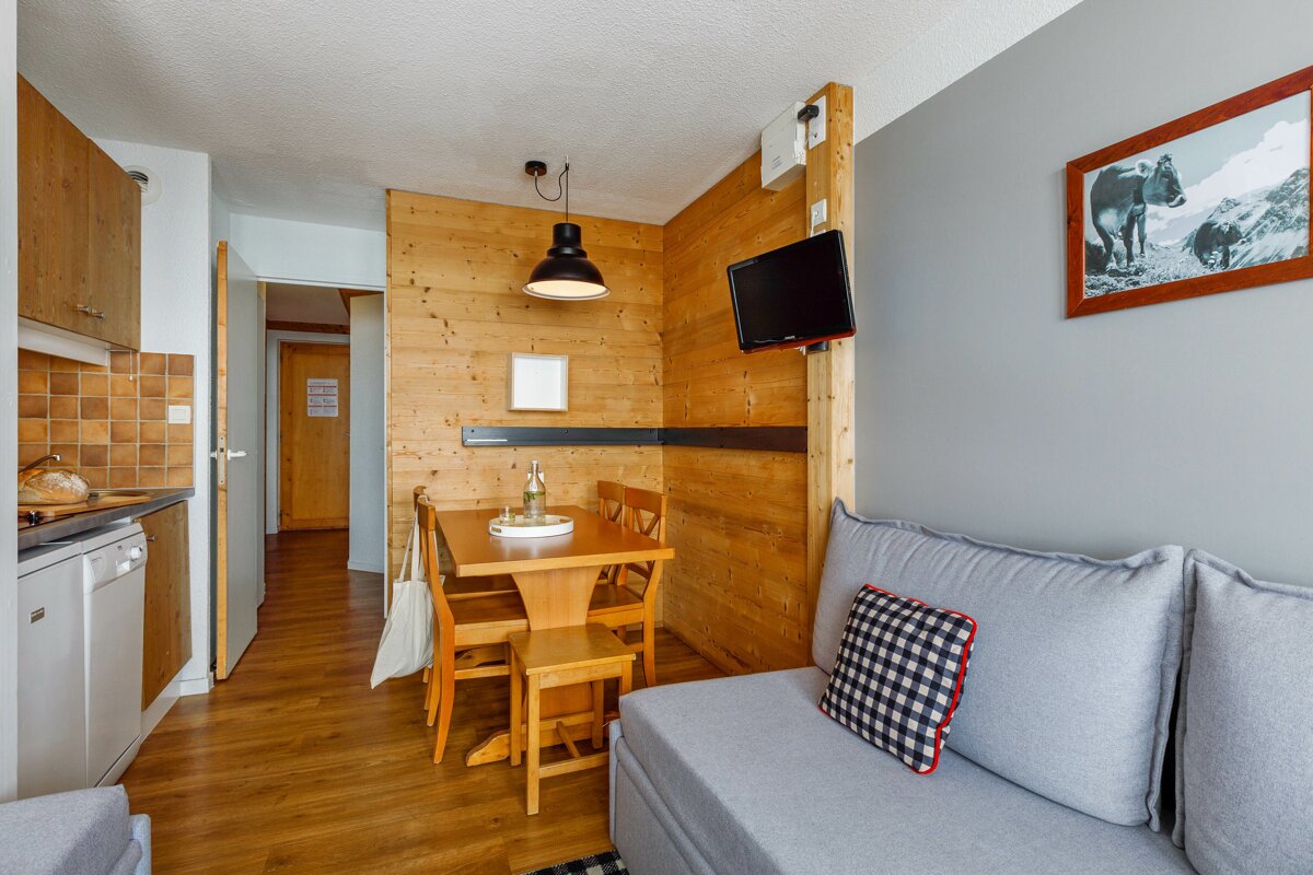 A living room with a table and chairs and a picture of a cow on the wall