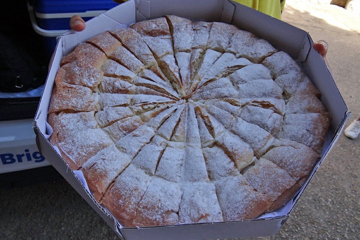 A person holding a pizza in a box that says brig