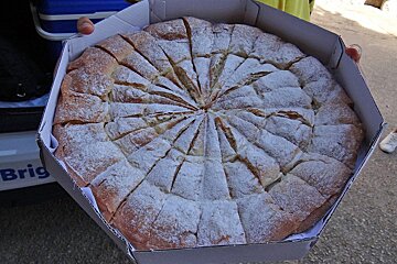 A person holding a pizza in a box that says brig
