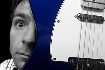 a man with a blue & white guitar