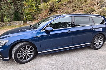 A blue car is parked on the side of the road