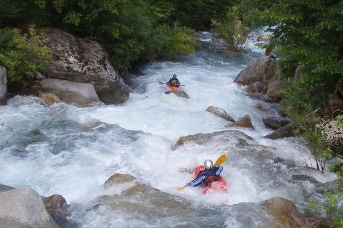 A man in a kayak is going down a river
