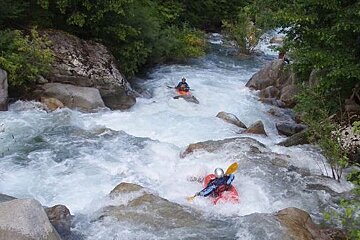 A man in a kayak is going down a river