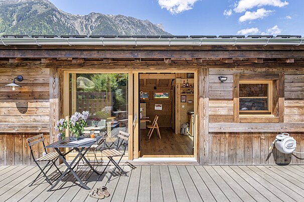 A wooden house with a table and chairs in front of it