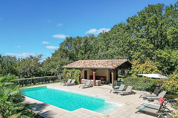 A large swimming pool with a gazebo in the background