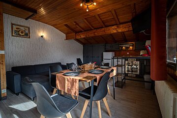 A living room with a table and chairs and a picture of a sunflower on the wall