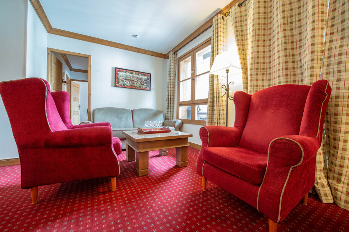 A living room with red chairs and a coffee table