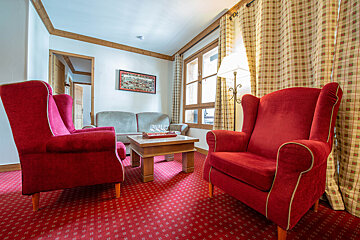A living room with red chairs and a coffee table