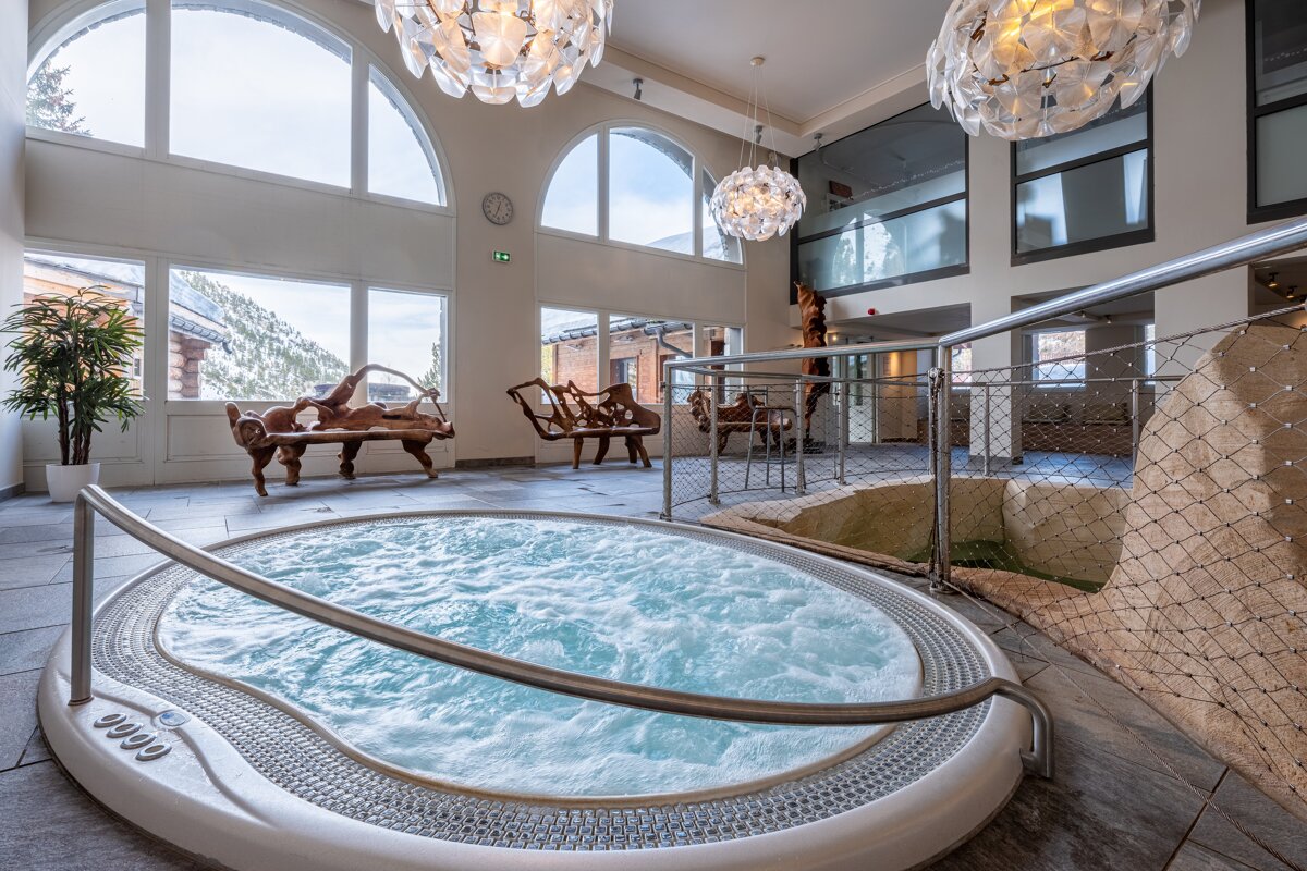 A jacuzzi in a large room with a clock on the wall