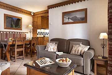 A living room with a couch and a table with a bowl of fruit on it