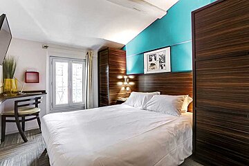 A hotel room with a bed and a chair