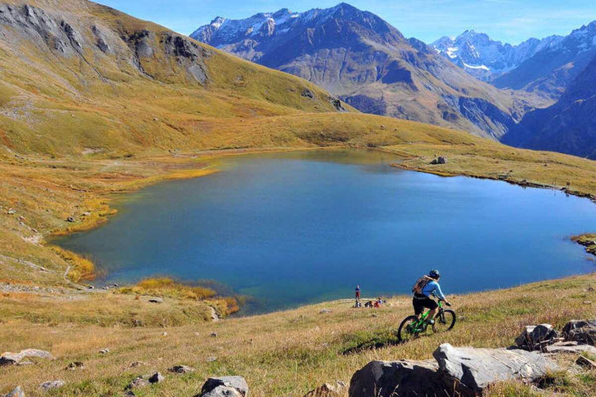 a mountain biker touring past a mountain lake