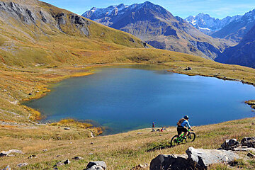 a mountain biker touring past a mountain lake
