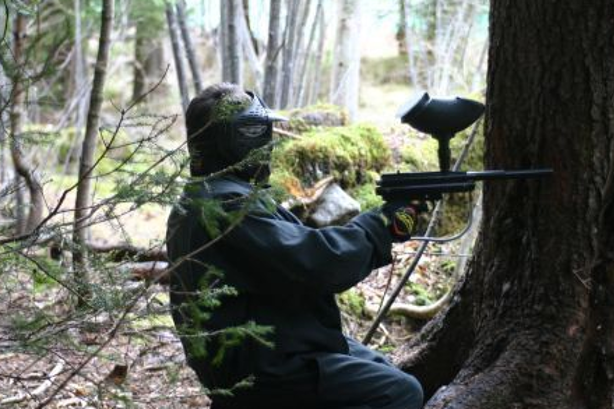 image of someone paintballing in the forest