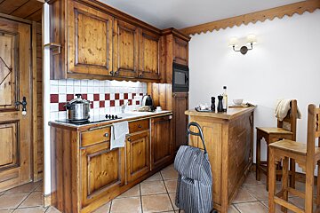 A kitchen with wooden cabinets and a stove top oven